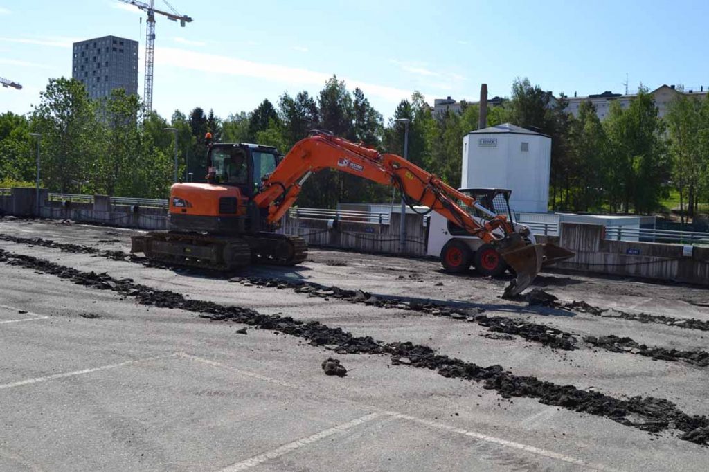 Orange grävskopa i arbete - Anläggningen och etableringen inför renoveringen av garaget i Vendelsö